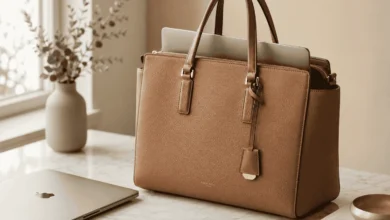 Tan pebbled-leather Coach laptop bag tote with a laptop inside on a desk
