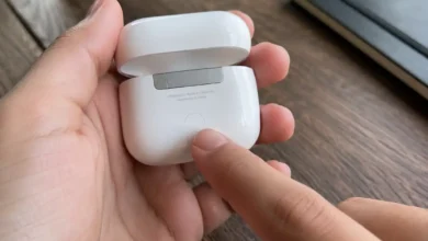 hand holding open AirPods case showing setup button for how to reset AirPods
